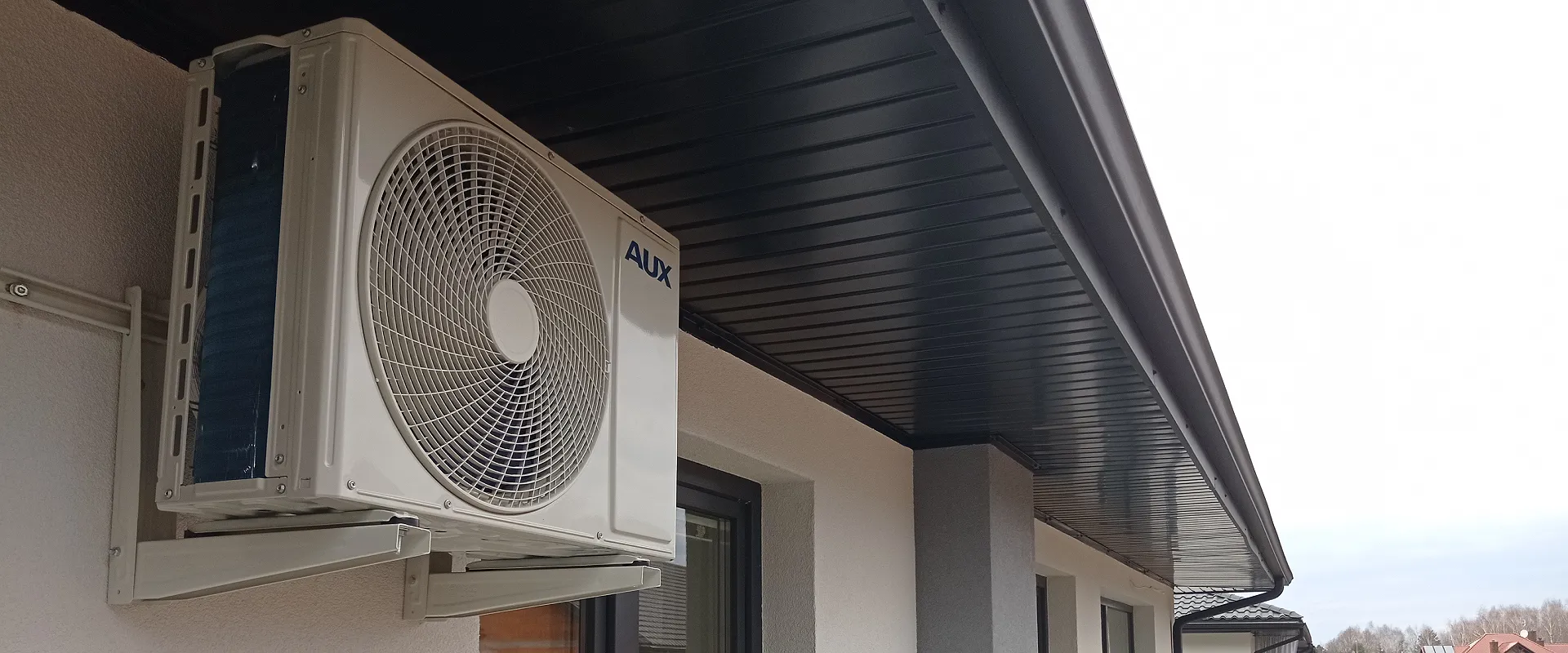 Wykonany przez Infomech montaż klimatyzacji w domu. Jednostka zewnętrzna na białej elewacji budynku