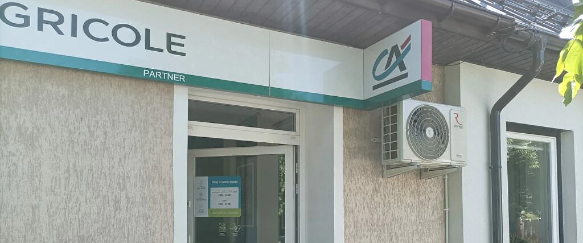 Jednostka zewnętrzna marki Rotenso zawieszona na elewacji budynku banku